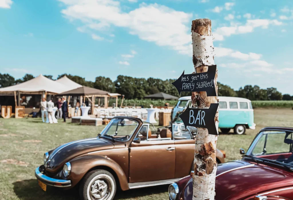 Oldtimer kevers bij een feest met een bordje naar de bar